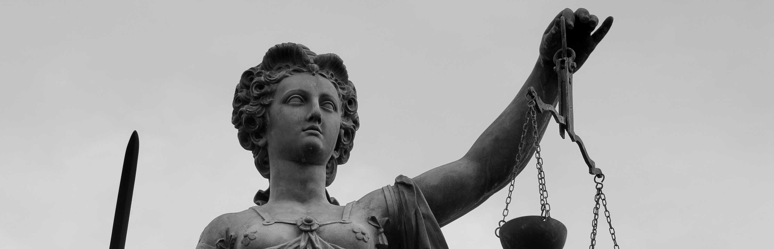 Farbfotografie des Gerechtigkeitsbrunnens mit Figur der Justitia, die Schwert und Waage in den Händen hält